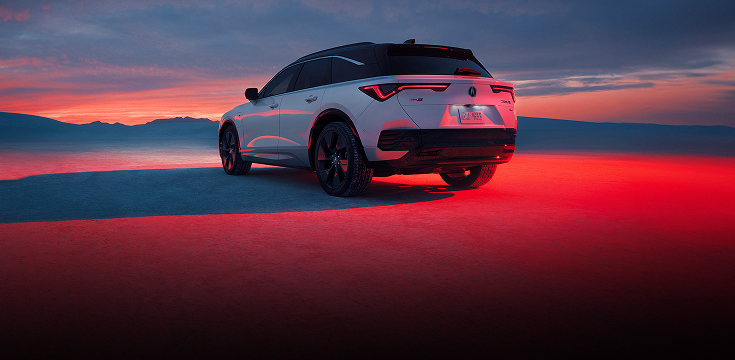 2024 Acura ZDX type S in Snowfall Pearl back parked on sand at sunset (Premium All-Electric SUV).