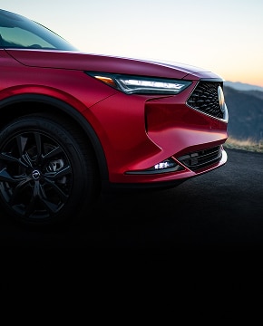 2024 Acura MDX A-Spec in Performance Red Pearl profile parked on a mountain road at sunset (Premium Performance SUV).