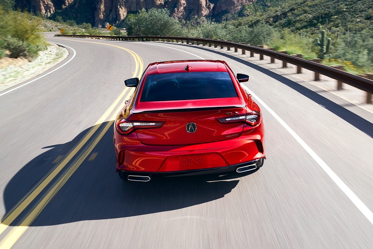 2020 Acura TLX A-Spec in Performance Red Pearl back driving away on a winding desert road (Premium Sport Sedan).