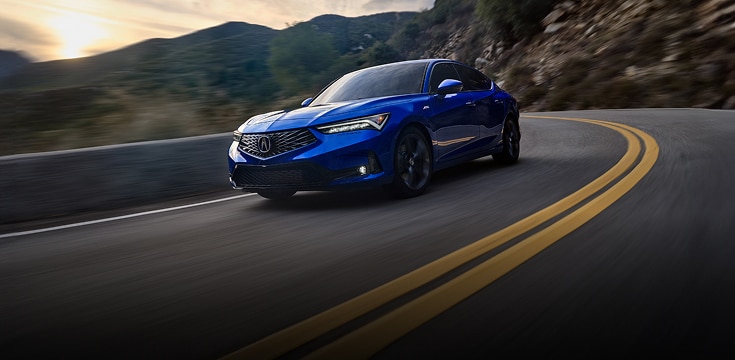 2024 Acura Integra A-Spec in Apex Blue Pearl front driving on a winding mountain road (Premium Sport Compact).