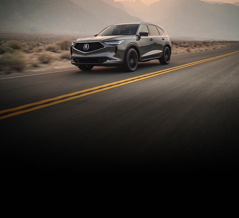 2024 Acura RDX Advance Package in Phantom Violet Pearl front driving on a dusty dirt road (Premium Sport Crossover SUV).