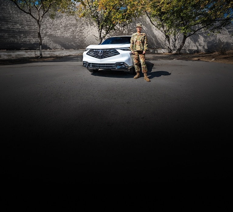 2026 Acura RDX A-Spec Advance in Platinum White Pearl front parked with a person in uniform (Premium Sport Crossover SUV). 2026 Acura RDX A-Spec Advance in Platinum White Pearl front parked with a person in uniform (Premium Sport Crossover SUV).