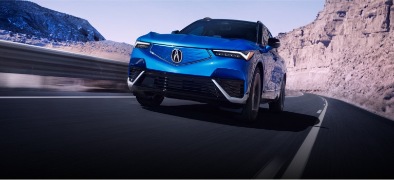 The Acura ZDX type S in blue driving down a road